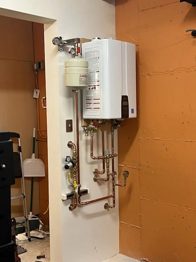 Plumbing technician inspecting water heater connections in Williamston